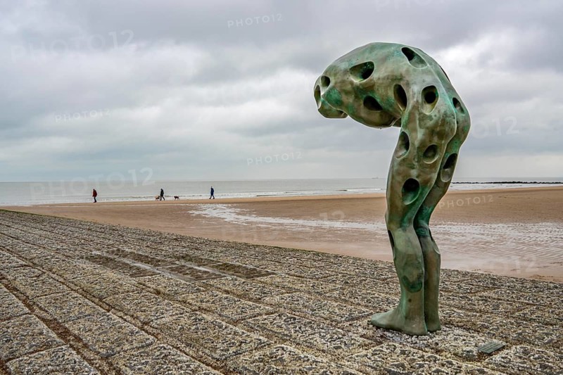 Art on the North Sea beach, in Knokke-Heist, Tomorrow Man by Cathérine François, is washed over by the sea at high tide, many permanent works of art in public spaces are spread around the city, here on the beach on Zeedijk-Knokke, beach promenade, dreary winter day, Belgium