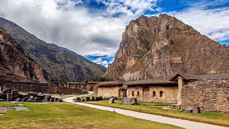 Mountain landscape with ancient ruins and blue sky, dramatic clouds, The Inca ruins of Ollantaytambo in the Andes of Peru