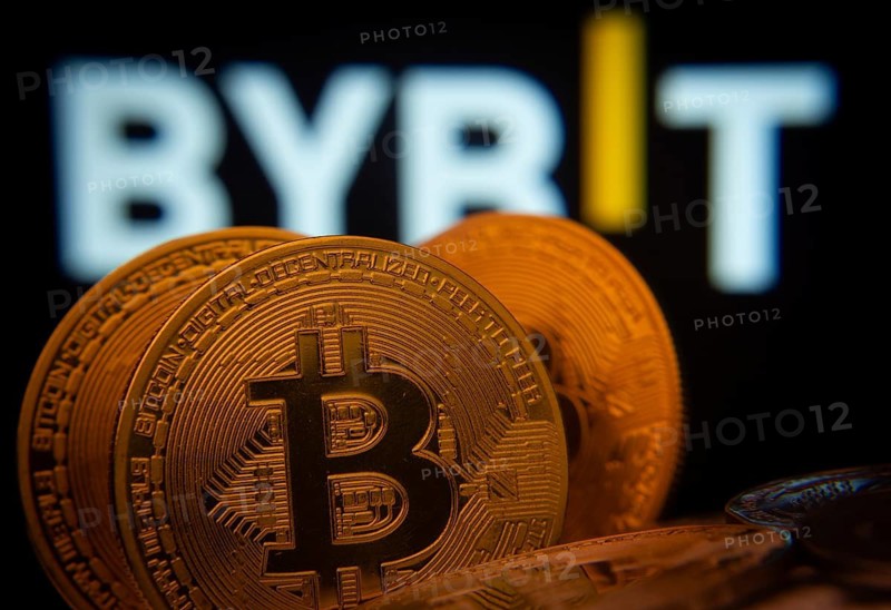 Dhaka, Bangladesh- 15 July 2025: Close-up of Bitcoin coins with the Bybit logo visible on a screen in the background