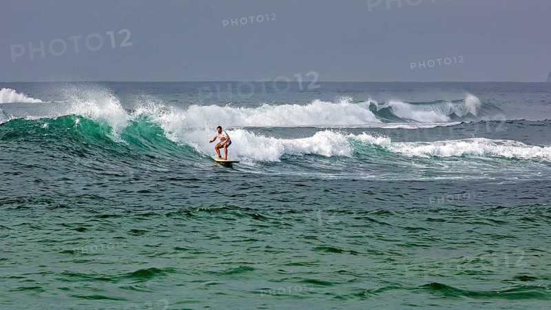 A surfer rides a wave in the vast ocean, surfers in the Indian Ocean near bile in Sri Lanka