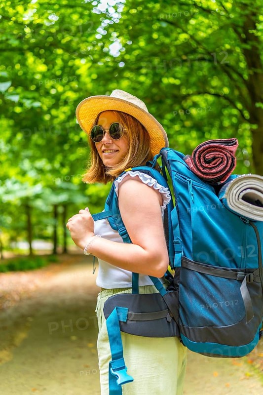 Vertical portrait of a caucasian active women turning to smile at camera while enjoying the forest on a sunny day