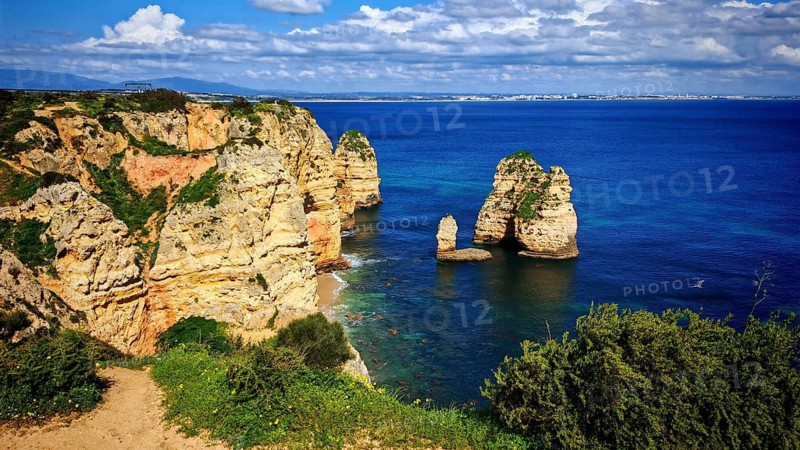 Coastal landscape with distinctive rock formations, rock arch and wide views of the ocean, Lagos, Algarve, Portugal