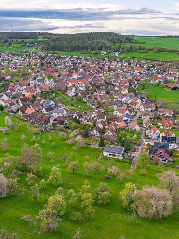 Aerial view of a quiet village with numerous houses, surrounded by green meadows and trees, Ostelsheim, district of Calw, Germany