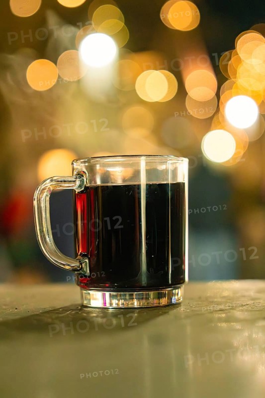 Hot mulled wine in a transparent cup with sparkling lights in the background, Night of Lights, Nagold, Black Forest, Germany