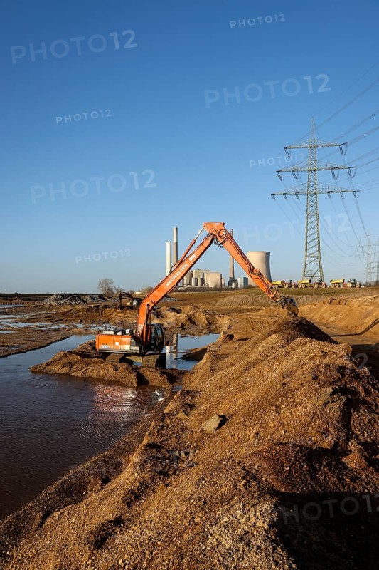Dinslaken, North Rhine-Westphalia, Germany, New Emscher estuary into the Rhine. Excavator in the construction site of the new Emscher estuary in front of the decommissioned STEAG Voerde coal-fired power station. The mouth of the Emscher into the Rhine is being moved almost 500 metres north from Dinslaken to Voerde. Fish will then be able to swim barrier-free up the new Emscher from the Rhine through a newly created floodplain area. Following the construction of a parallel sewer, the Emscher has been completely free of sewage since January 2022. The river was previously an open, above-ground combined sewer with rainwater and wastewater