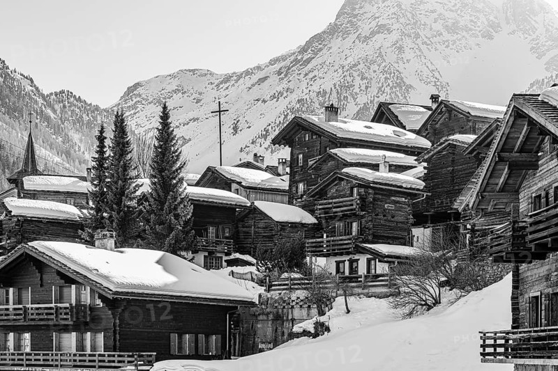 Snow-covered old farmhouses, large wooden cross, black and white photo, historic town center, Grimentz, Val d'Anniviers, Valais Alps, Canton of Valais, Switzerland