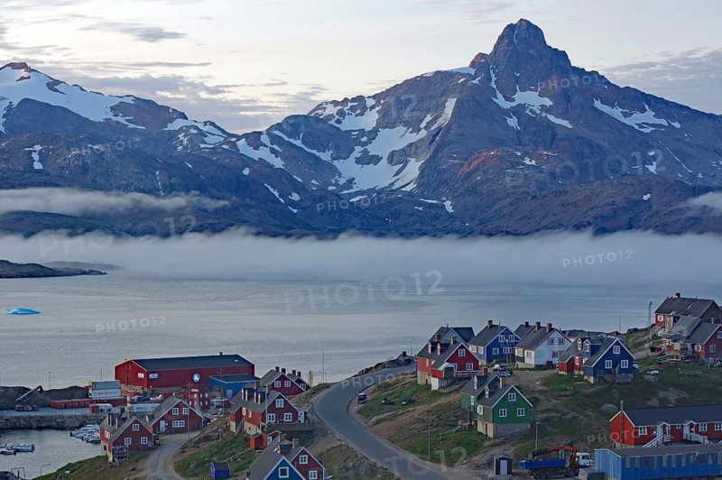 A waterfront village with fog and impressive mountains in the background, Tasilaq, Arctic, Greenland, Denmark
