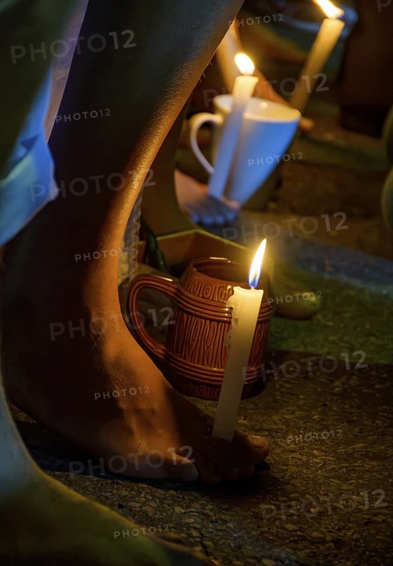 Feet holding a candle during prayer in a typical Umbanda ceremony, Brazil