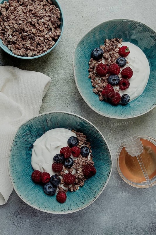 Breakfast, two bowls, yogurt, muesli with berries, and honey, homemade, no people