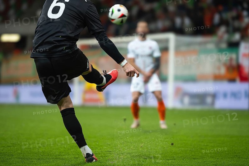 Soccer player kicks the ball during football match. Opponent player in the wall