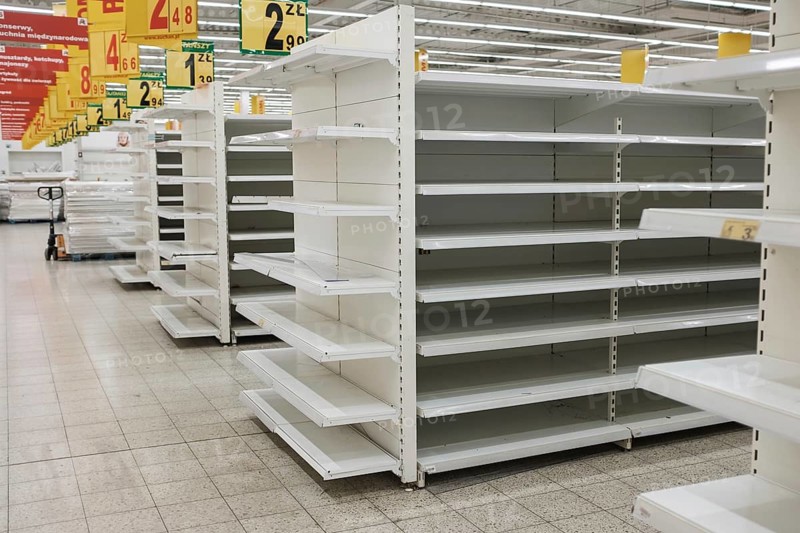 Empty shelfs in the supermarket. At the top, Polish prices and subtitles