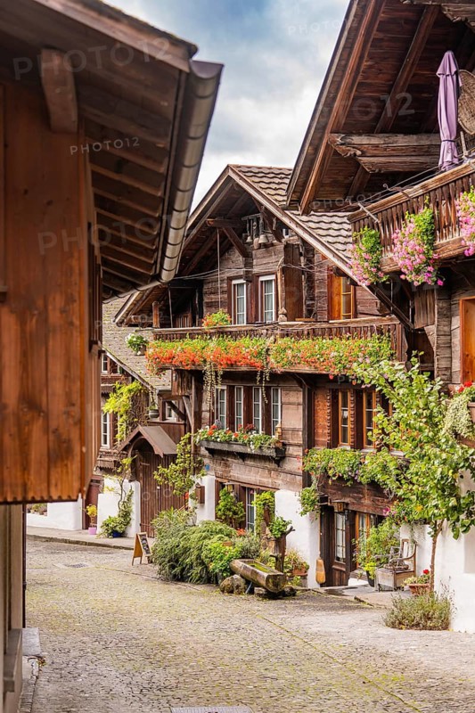 Picturesque alley with half-timbered houses and balconies decorated with flowers, Lake Brienz, Brienz, Switzerland