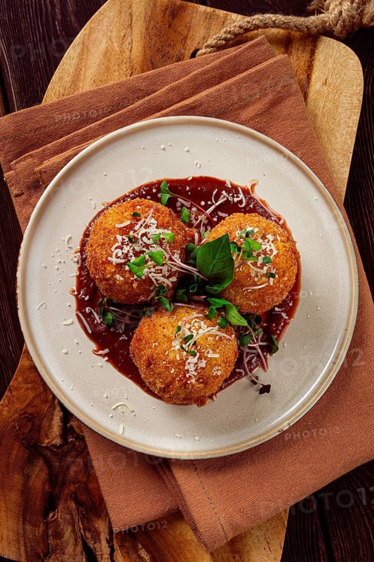 Crispy Arancini appetizer, with parmesan cheese and microgreens, plate, tomato sauce, homemade, no people