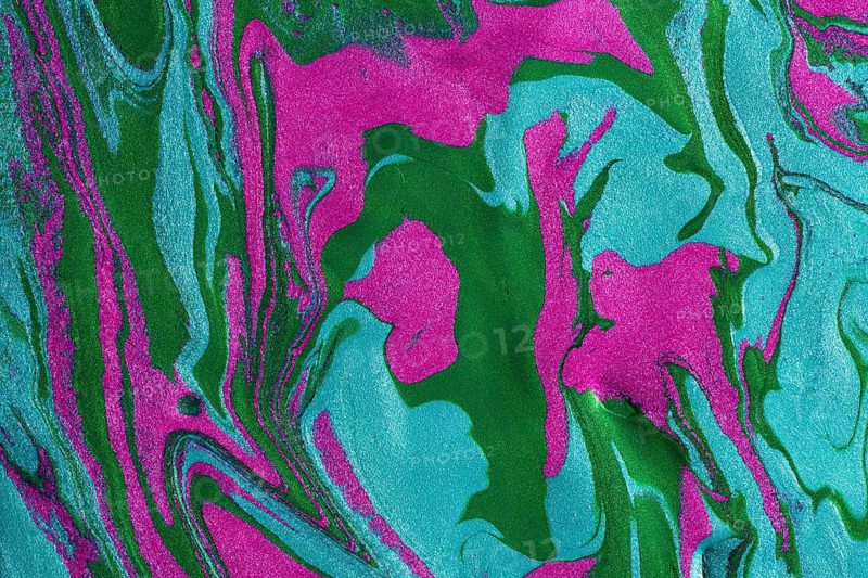 A close-up image of swirling metallic paints mixing pink and green hues, creating a vibrant textured background