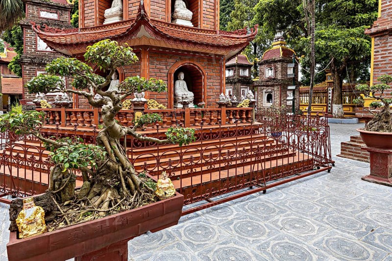 Detail of a pagoda with bonsai trees and ancient architecture in a Buddhist temple complex, The Tran Quoc Pagoda at Westlake in Hanoi Vietnam