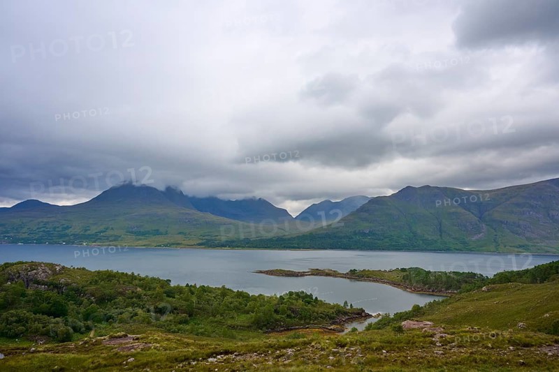 View of a lake with surrounding mountains under heavily cloudy sky, Loch Torridon, Kenmore, Strathcarron, Scotland, United Kingdom, Great Britain