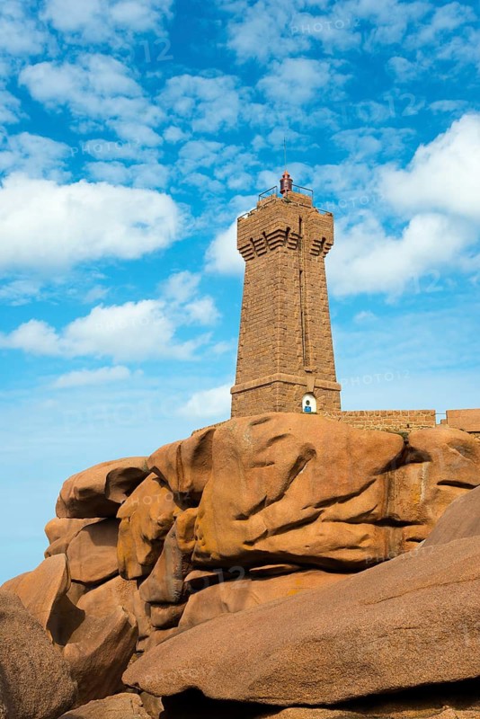 A lighthouse perched on massive rocks under a blue sky, Phare de Men Ruz, Ploumanac'h, Ploumanach, Pointe de Squewel, Perros-Guirec, pink granite coast, Côte de Granit Rose, Brittany, France
