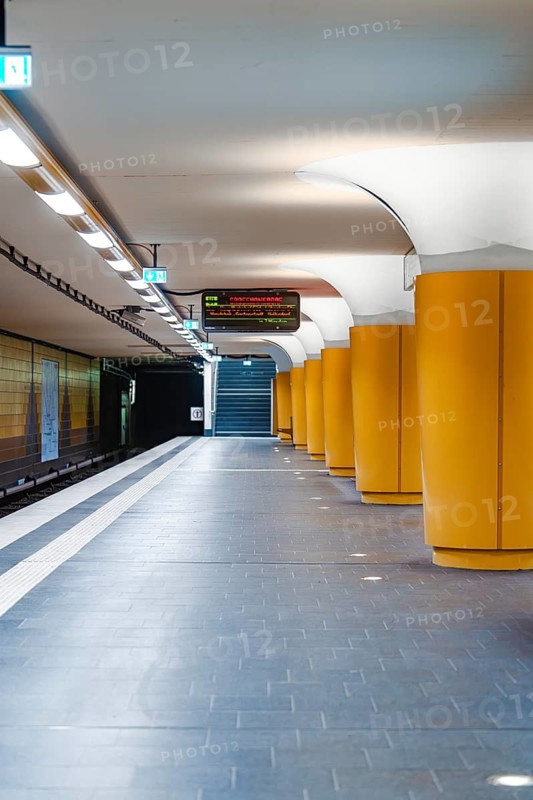 Modern underground station with yellow columns and bright lighting, Hamburg, Germany