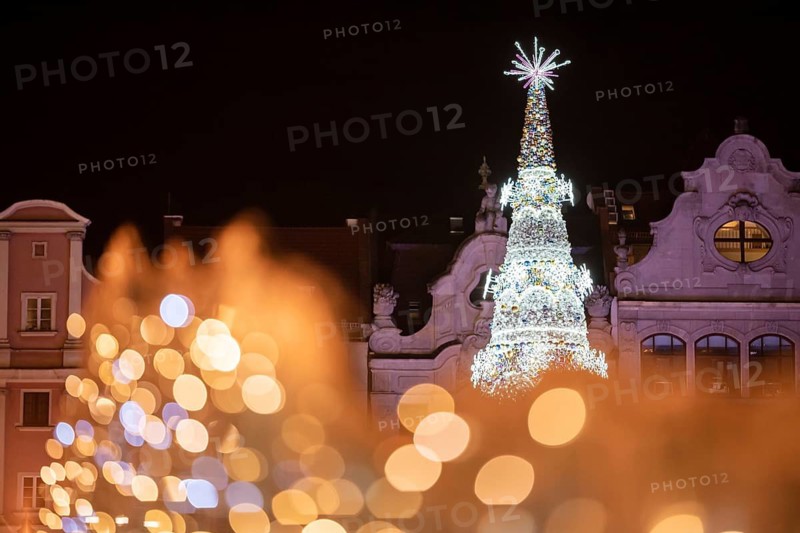 Christmas fair in the market square of Wroclaw, Poland. Christmas tree behind lights which gift beautiful bokeh