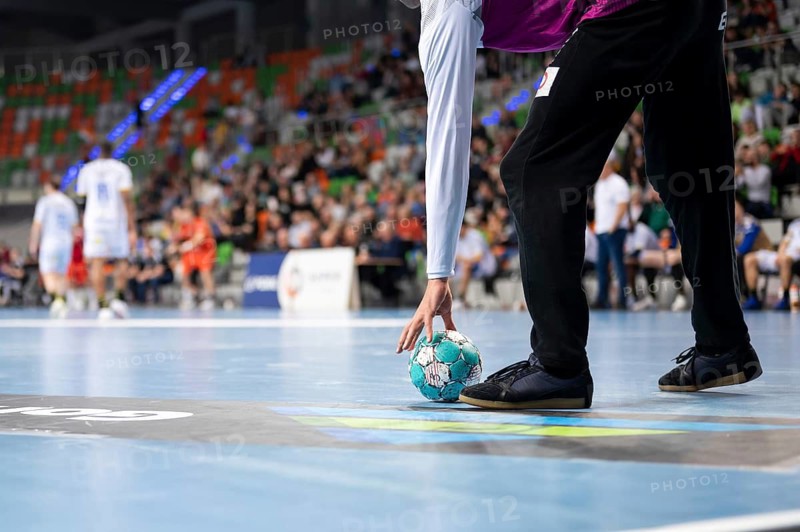 Handball goalkeeper raises ball during the match