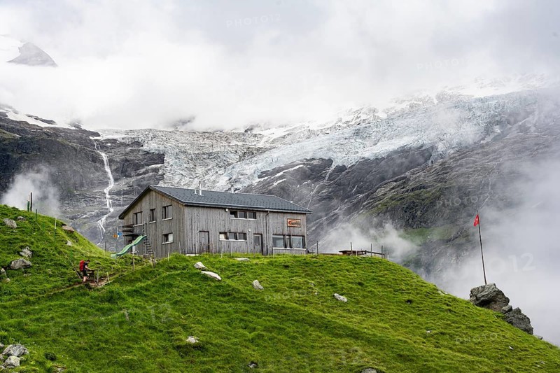 Berghaus Bäregg mountain hut, cloudy mountain landscape with Grindelwald-Fiescherfirn glacier, Bernese Alps, Bernese Oberland, Switzerland