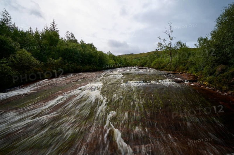 A calm river flows through a forest under cloudy skies, Victoria Falls, Slattadale, Achnasheen, Scotland, United Kingdom, United Kingdom