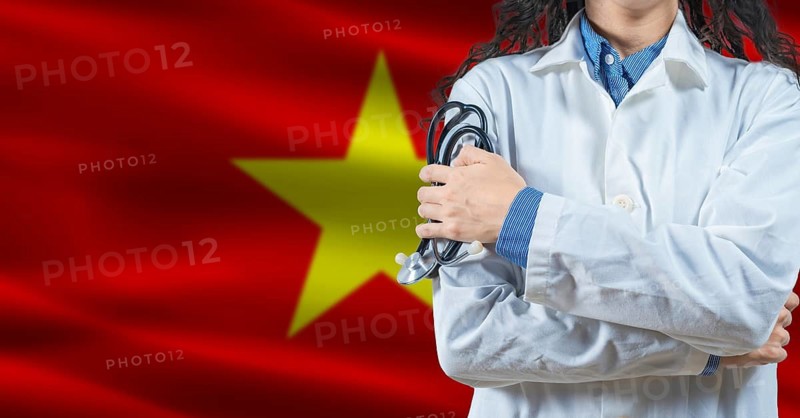 Healthcare professional with Vietnam flag background. Professional doctor holding stethoscope on Vietnam flag background