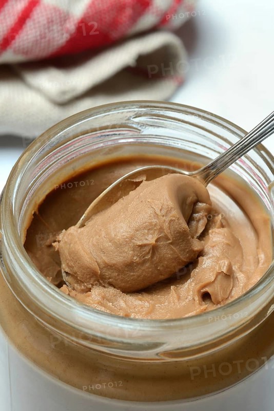 Almond cream in jar with spoon, almond spread
