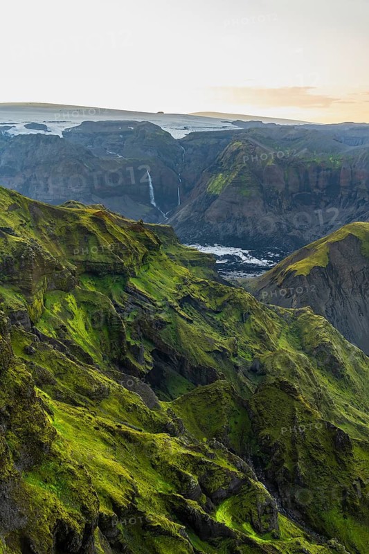Moss-covered mountains at sunset, waterfalls on a cliff at Myrdalsjökull glacier, Pakgil, Iceland