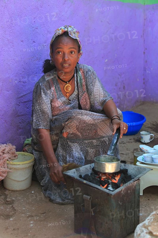 In the highlands of Abyssinia, in the village of Sina, young woman roasting coffee for the coffee ceremony, Ethiopia