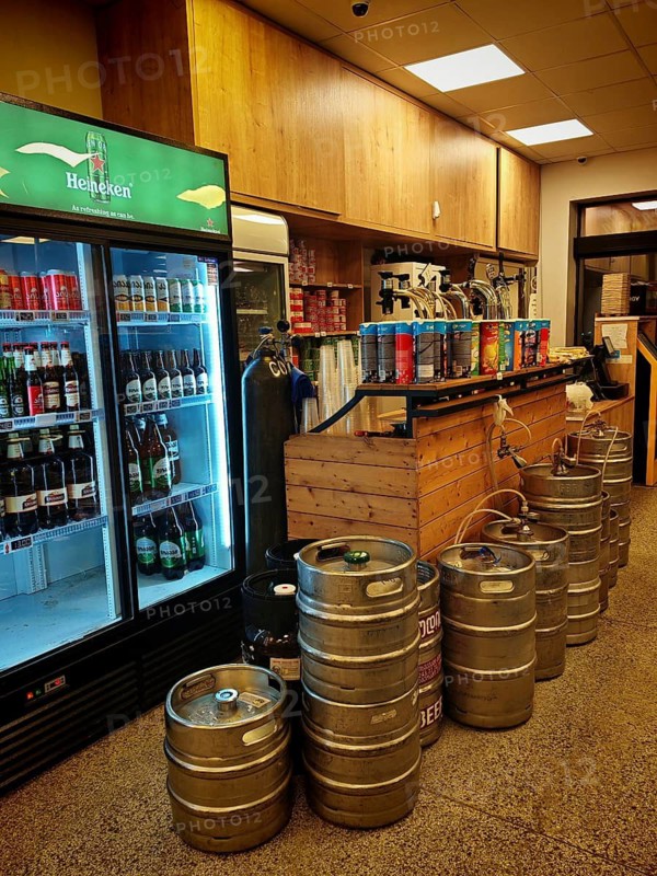 Beverage market with beer kegs, cooling rack and wooden bar in industrial style, draft beer in supermarket, Georgia