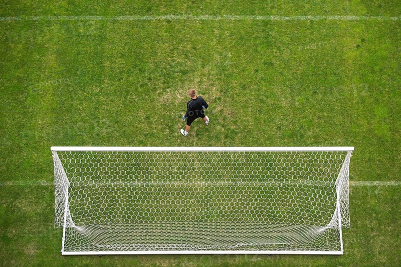 Soccer goalkeeper in front of goal - view from above