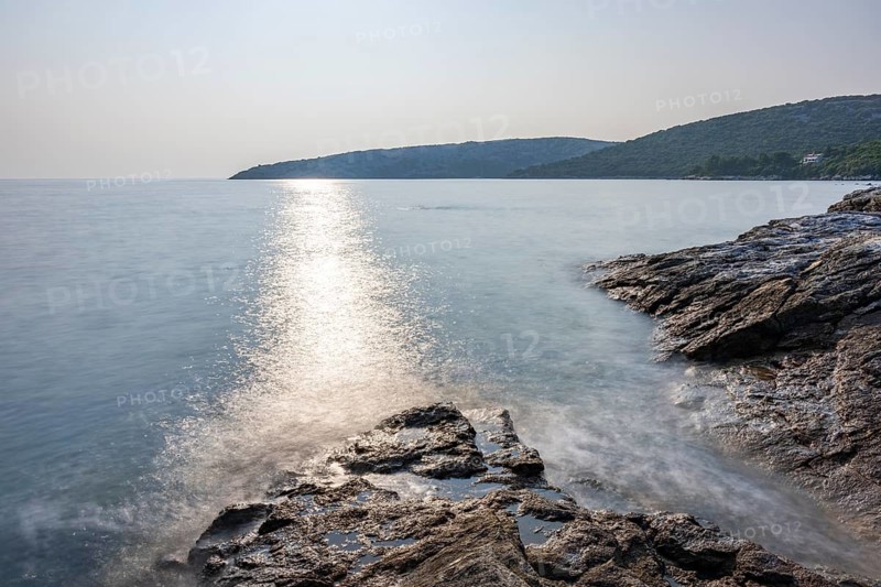 Crystal clear and turquoise water on the beach of Ustrine Bay on a sunny day on the island of Cres, long exposure, Croatia