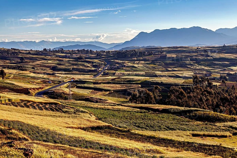 Extensive landscape with fields and hills under a clear sky, The landscape in the Sacred Valley of the Incas in Peru