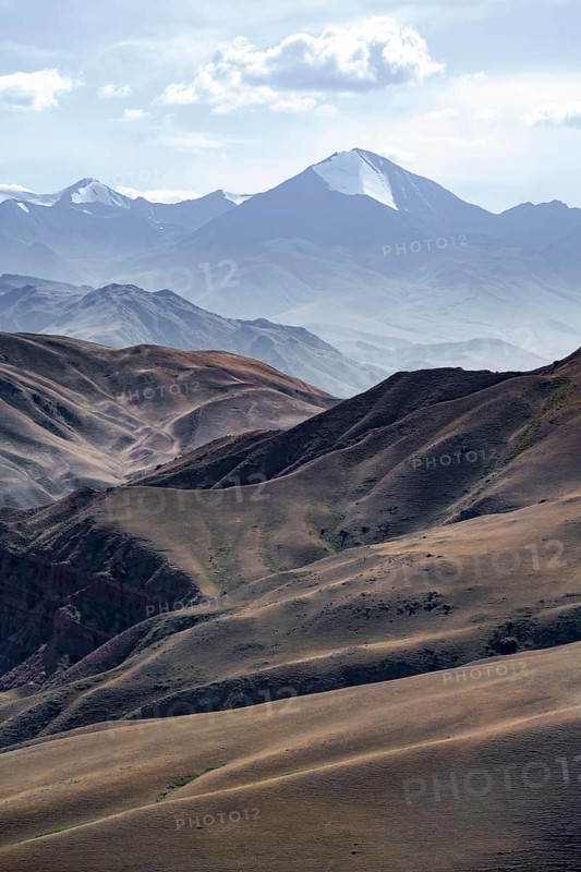 View over eroded mountainous landscape with brown hills, mountains and steppe, Chuy province, Kyrgyzstan