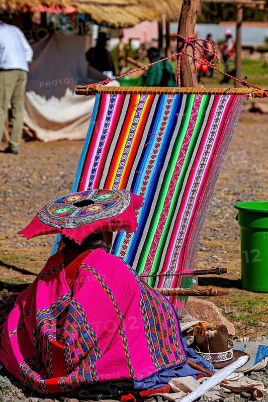 Woman wearing traditional clothes at a loom in a rural setting, elderly traditionally dressed lady from Peru weaving a cloth