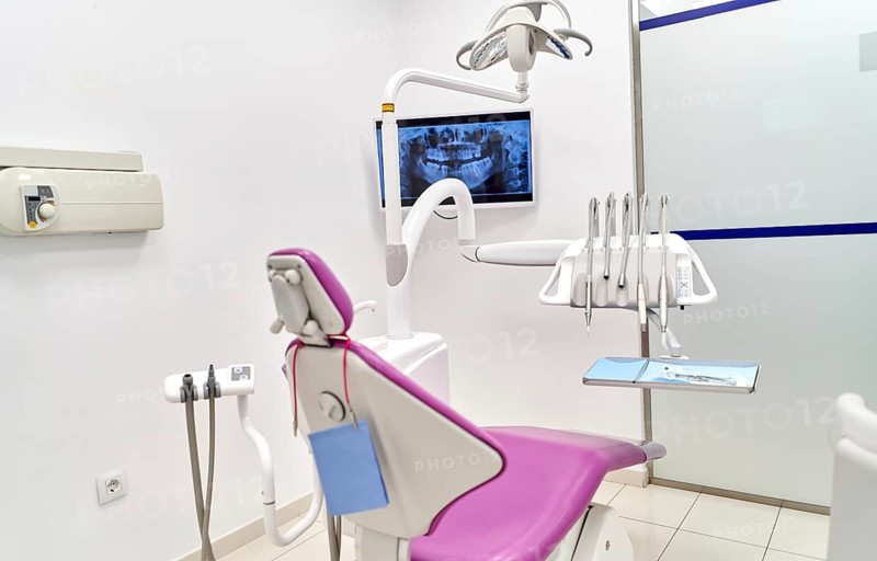 A modern dental clinic showcasing state-of-the-art equipment, including a dental chair, various dental tools, and a digital X-ray display providing comprehensive dental care