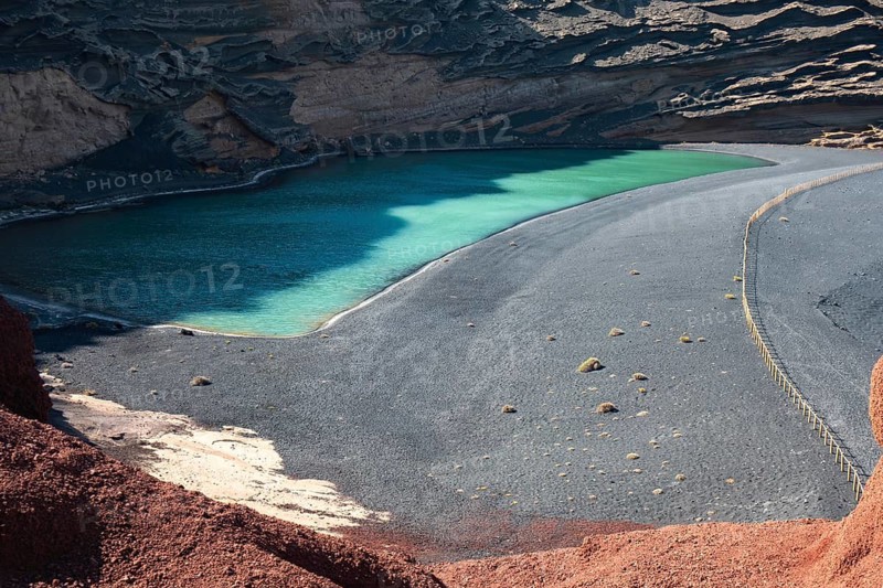 A captivating emerald lake of El Golfo in Lanzarote, Canary Islands. Nestled against dramatic volcanic cliffs and surrounded by dark sands, it's a mesmerizing natural wonder