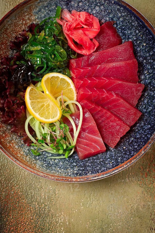 Tuna sashimi with daikon and wakame salad, pickled ginger, in a bowl