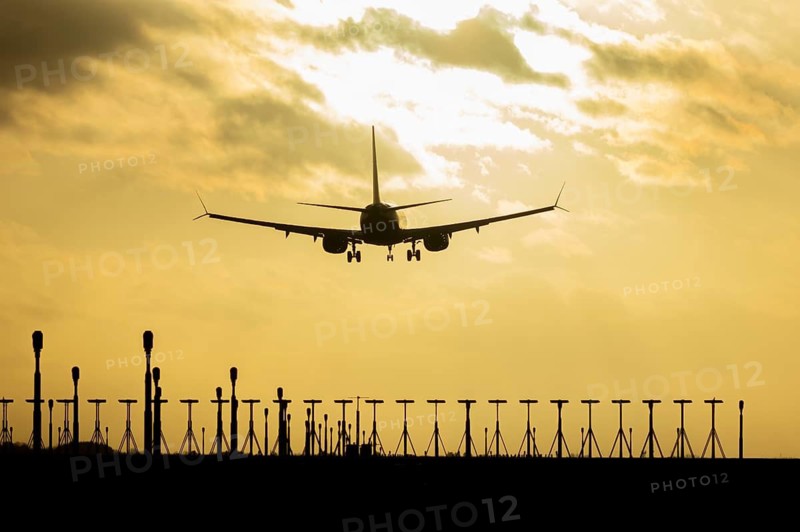 Boeing 737 commercial passenger airliner jet aircraft of Ryanair airways in flight on approach to land over runway lights at sunset at London Stansted airport, Essex, England, United Kingdom