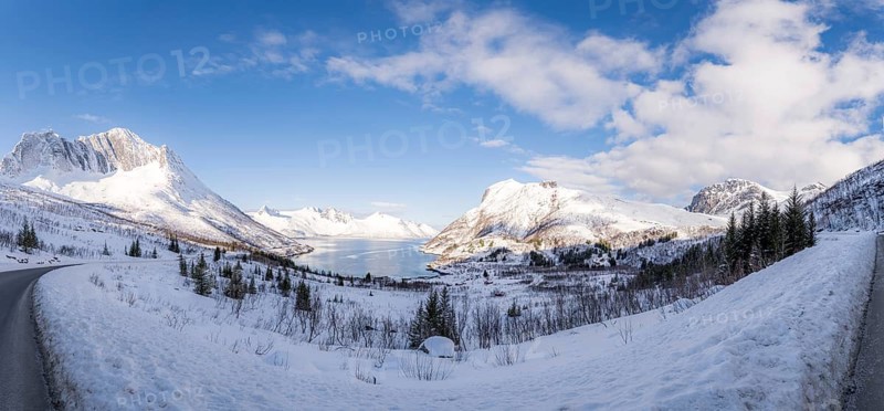 A breathtaking snowy mountain landscape of Mefjordbotn, Norway, showcasing serene snow-covered peaks under a vibrant blue sky, perfect for winter exploration