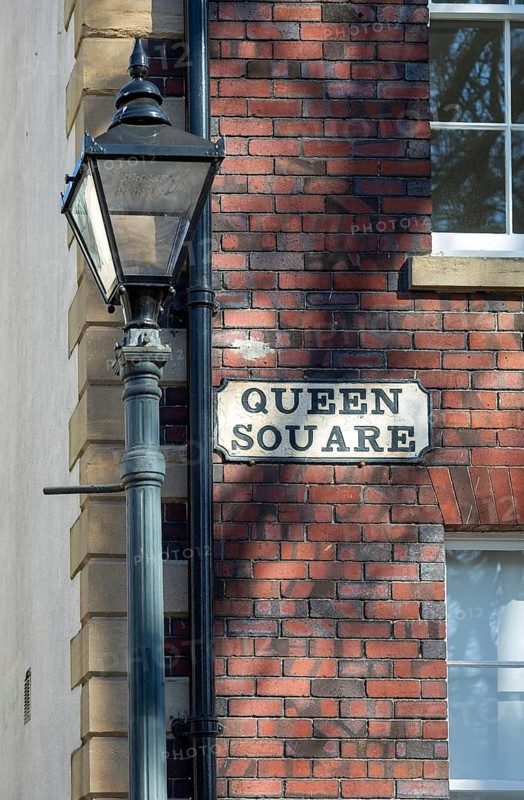 Historic lamppost and street sign on red brick Georgian building, Queen Square, Bristol, England, UK