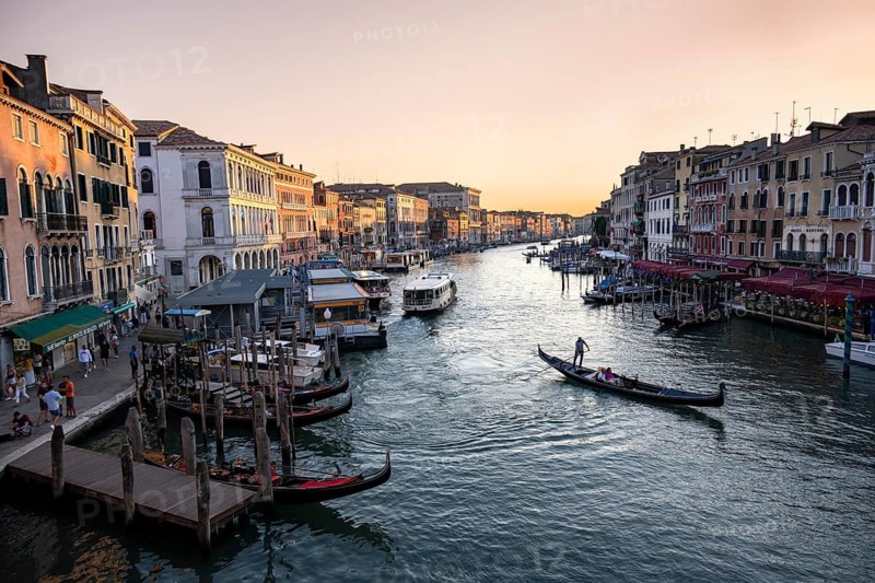 View of the Grand Canal with gondoliers at sunset, picturesque evening mood with palazzos on the canal, view from the Rialto Bridge, Venice, Veneto, Italy