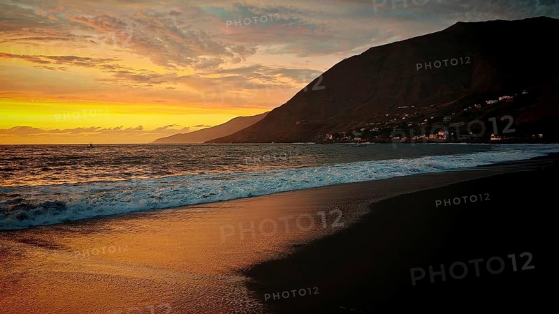 Romantic sunset on the beach with volcanic sand in front of mountains with shade and light at the sea, hiking, view towards Tarrafal de Monte Trigo, Santo Antao, Cabo Verde, Cape Verde, Cape Verde