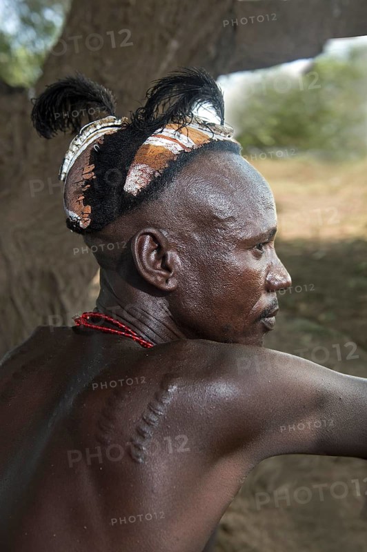 Young man with traditional clay headdress and scarred tattoos, Dassanetsch ethnic group, Southern Omo Valley, Ethiopia