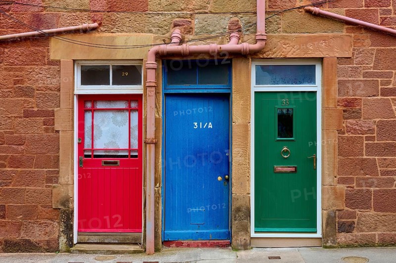 A series of colorful doors in a building with red, blue and green paint, North Berwick, East Lothian, Scotland, United Kingdom, Great Britain