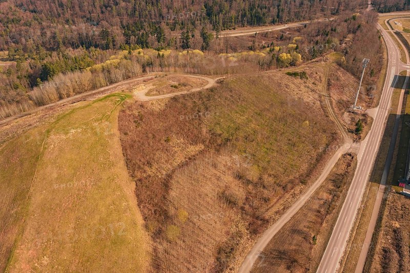 Aerial view of a hill surrounded by roads in the forest with bare and vegetated areas, old deposit in front of PV Bau, Lindenrain, Calw, Germany
