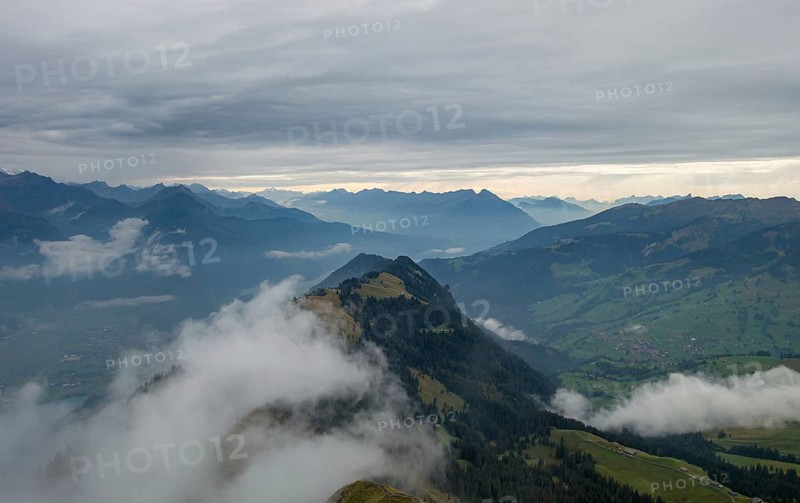 An early morning view of the mist-covered mountain peaks in the Bernese Alps, showcasing the serene and hazy landscape below