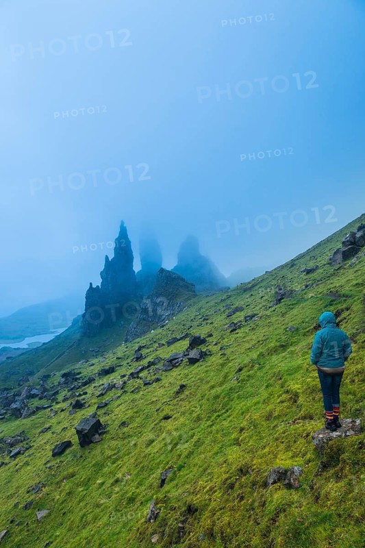 UK. Scotland. Isle of Skye. A tourist looking at the Old Man of Storr during a storm