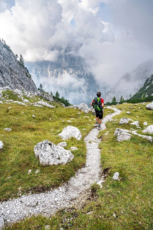 Mountaineer on a hiking trail, cloudy mountains, descent over the Ofental, mountain tour on the Hochkalter, Hochkalter crossing, Berchtesgaden Alps, Bavaria, Germany